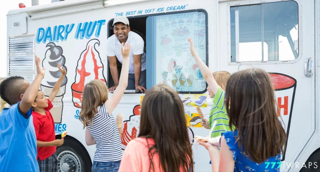 A cheerful group of children gathers in front of a dairy hut ice cream truck with fleet wraps, eagerly anticipating their ice cream orders